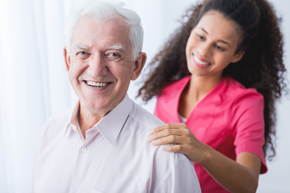older man smiling with caregiver