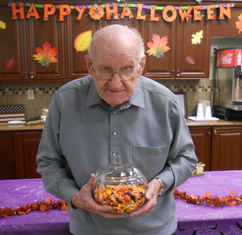 Elderly Man Holding Jar of Candy Corn | Retirement Communities Long Island