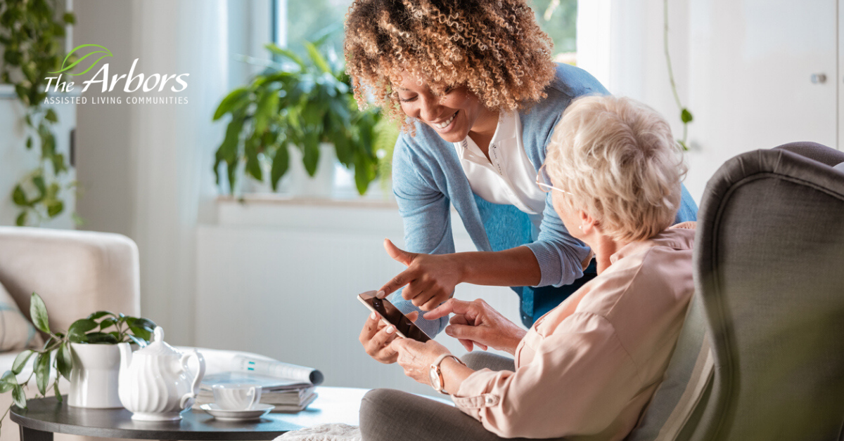 caretaker helping elderly woman with app on phone